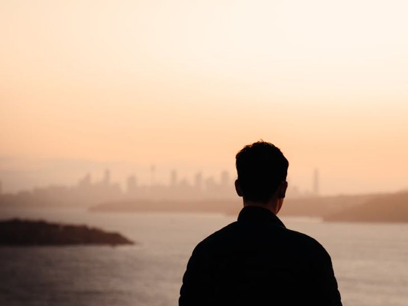 Person looking into the distance near a large window.