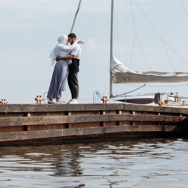 Stones balanced on top of each other by water.